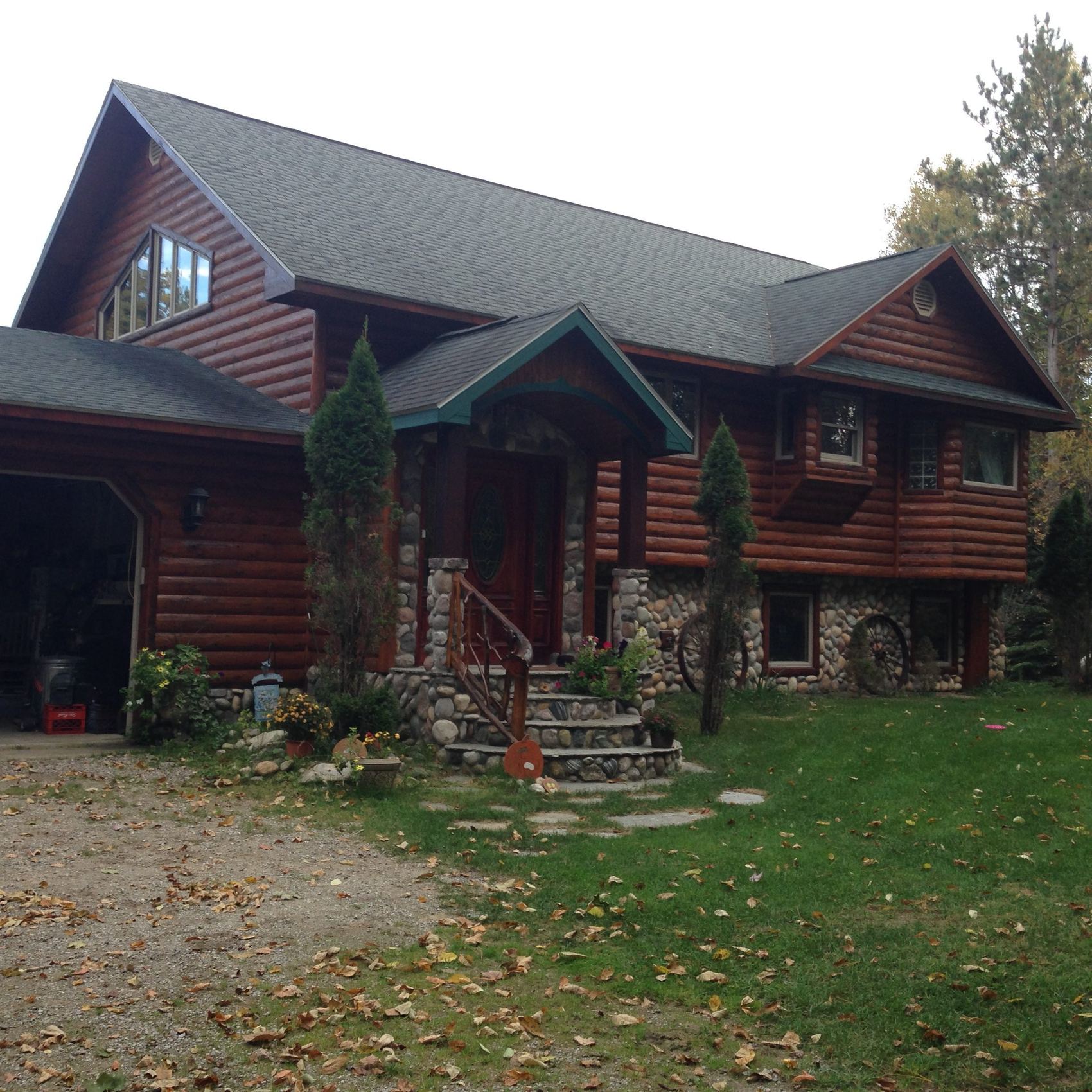 Log cabin in Walloon after re-siding and staining by TNT Construction