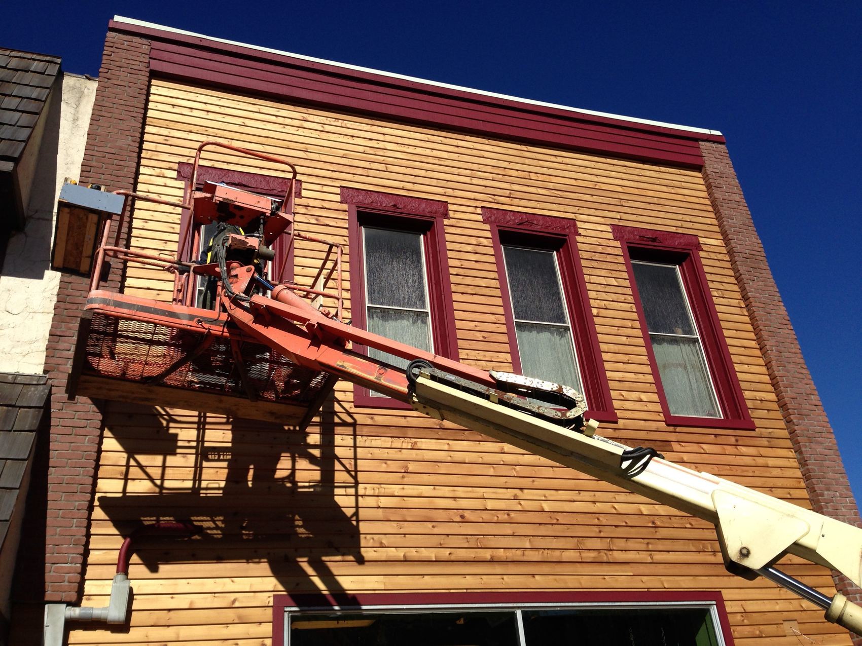 Crew on a lift putting new siding on a commercial building in Petoskey